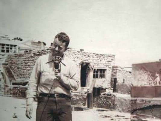 A man standing in front of an old building.