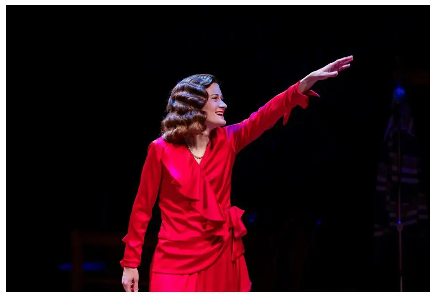 A woman in red dress pointing to the sky.