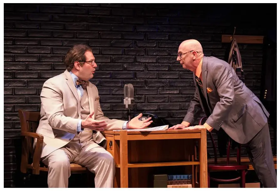 Two men in suits are sitting at a table