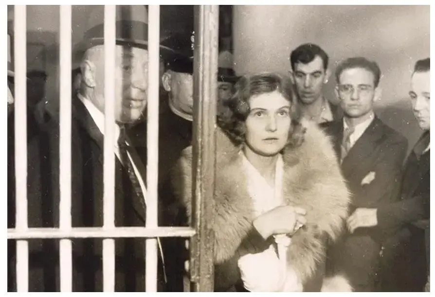 A group of people standing around in front of a cage.