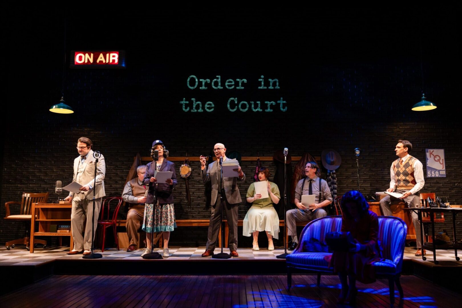 A group of people on stage in front of a sign.