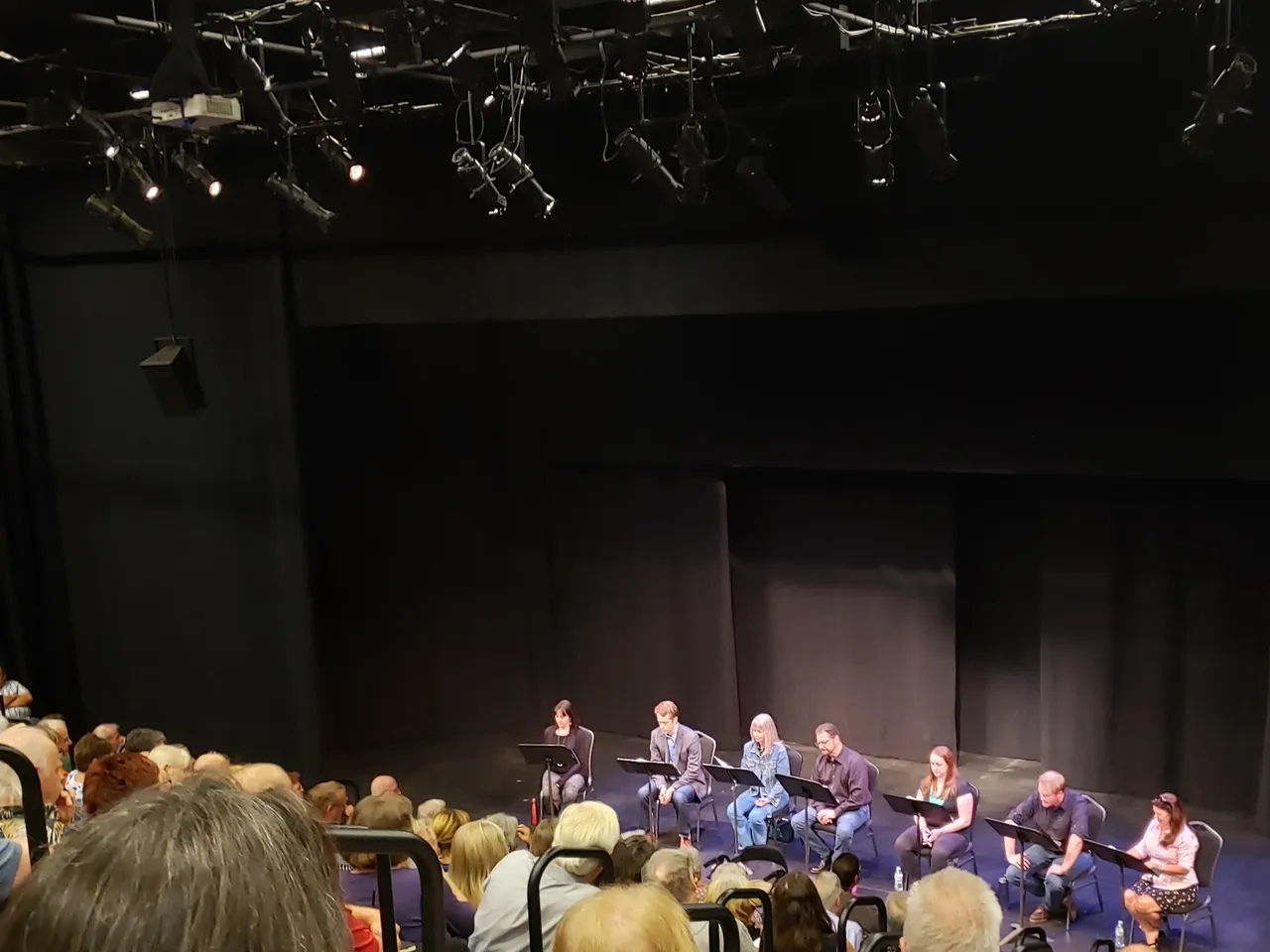 A large group of people sitting in front of a stage.