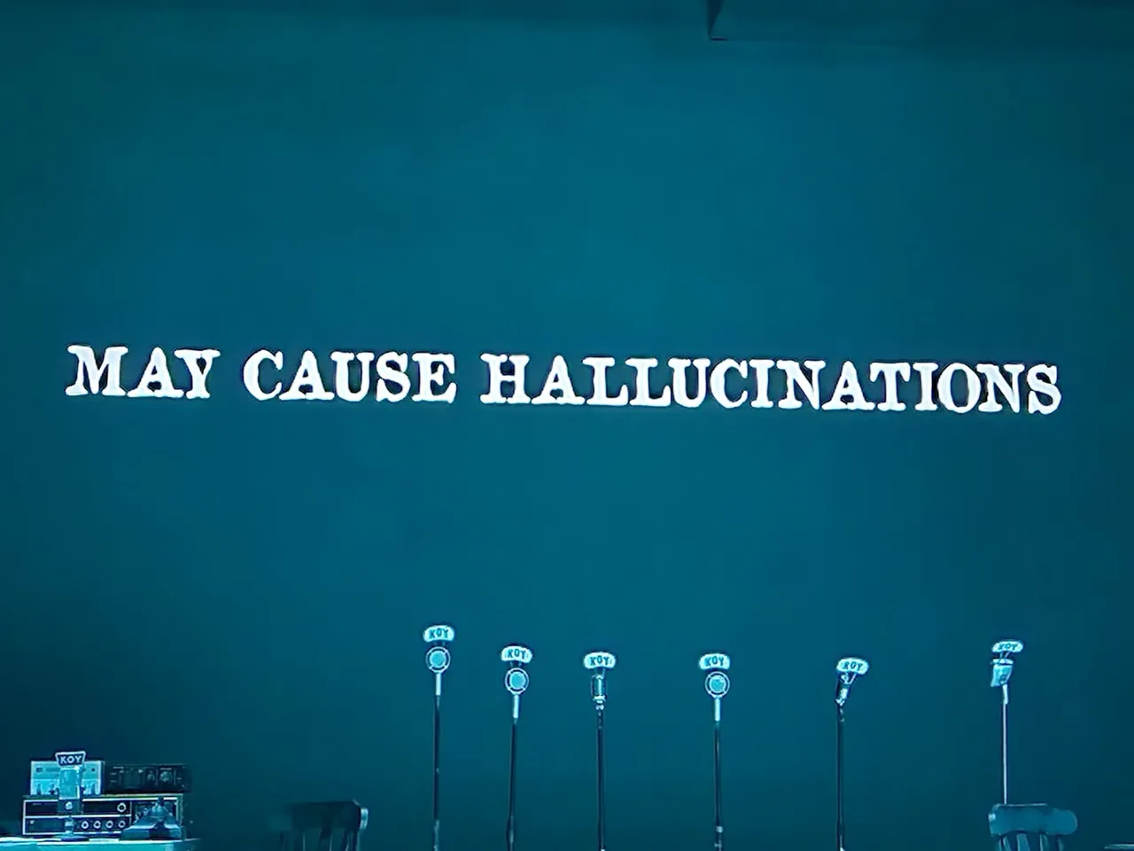 A wall with the words " pay cause hallucination ".